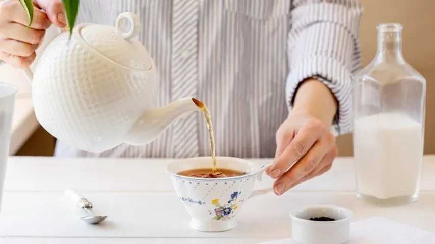 Mujer vertiendo té en una taza. (Foto: Freepik)